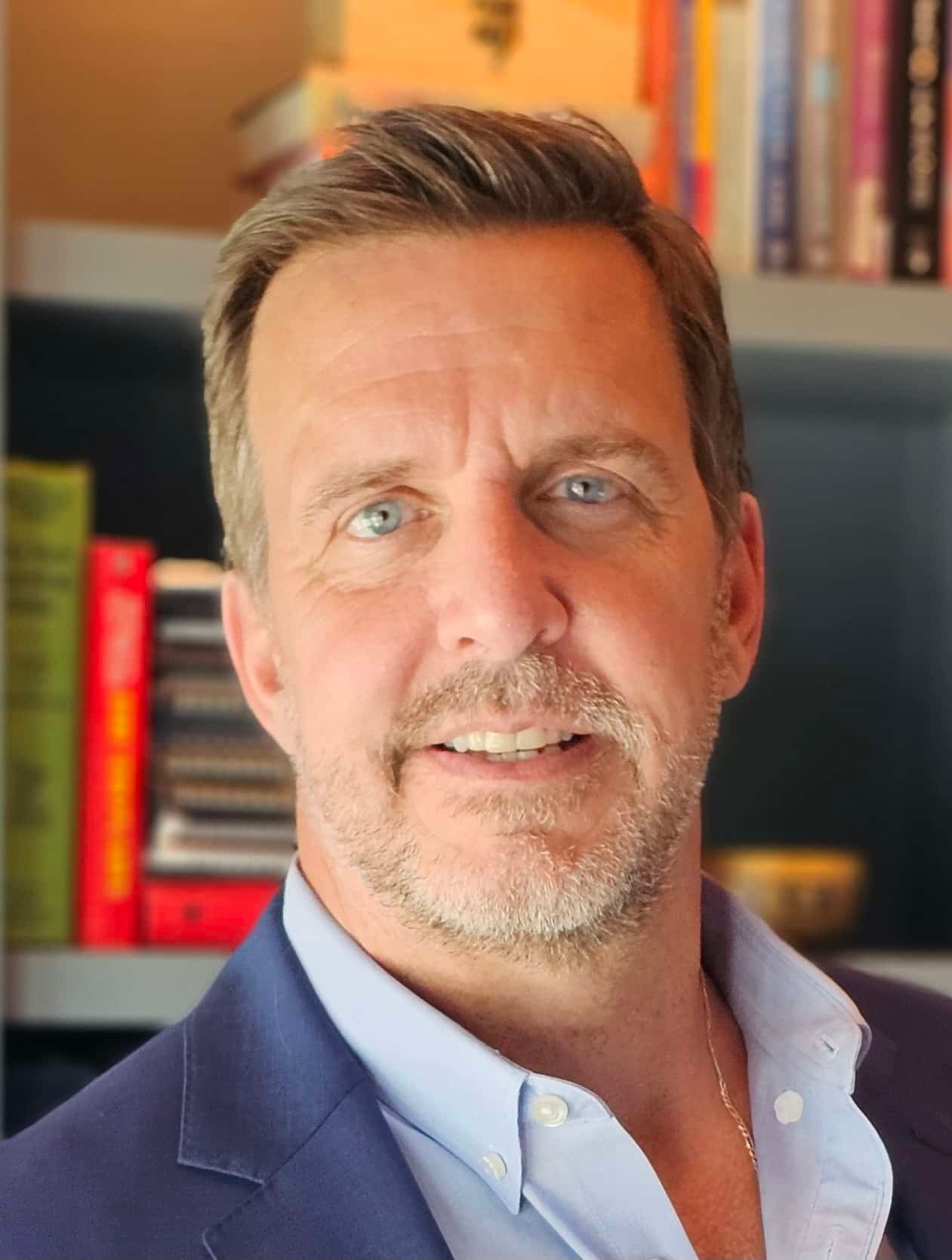 confident smiling man portrait bookshelf blur